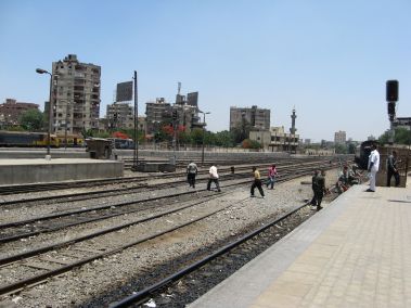 Pedestrians cross tracks at Ramses Station platform.
